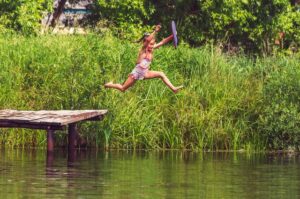 Girl jumping into pond